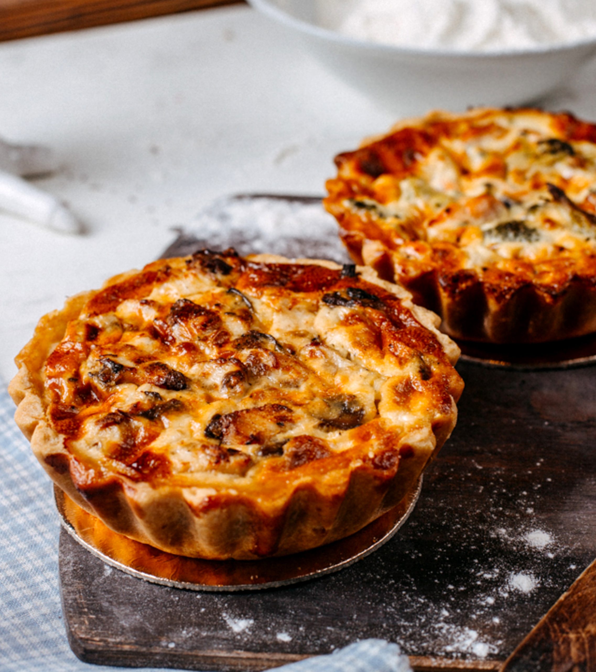 side view of mini pie with meat and vegetables on a wooden cutting board